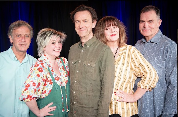 Five people in casual clothes stood side by side on stage