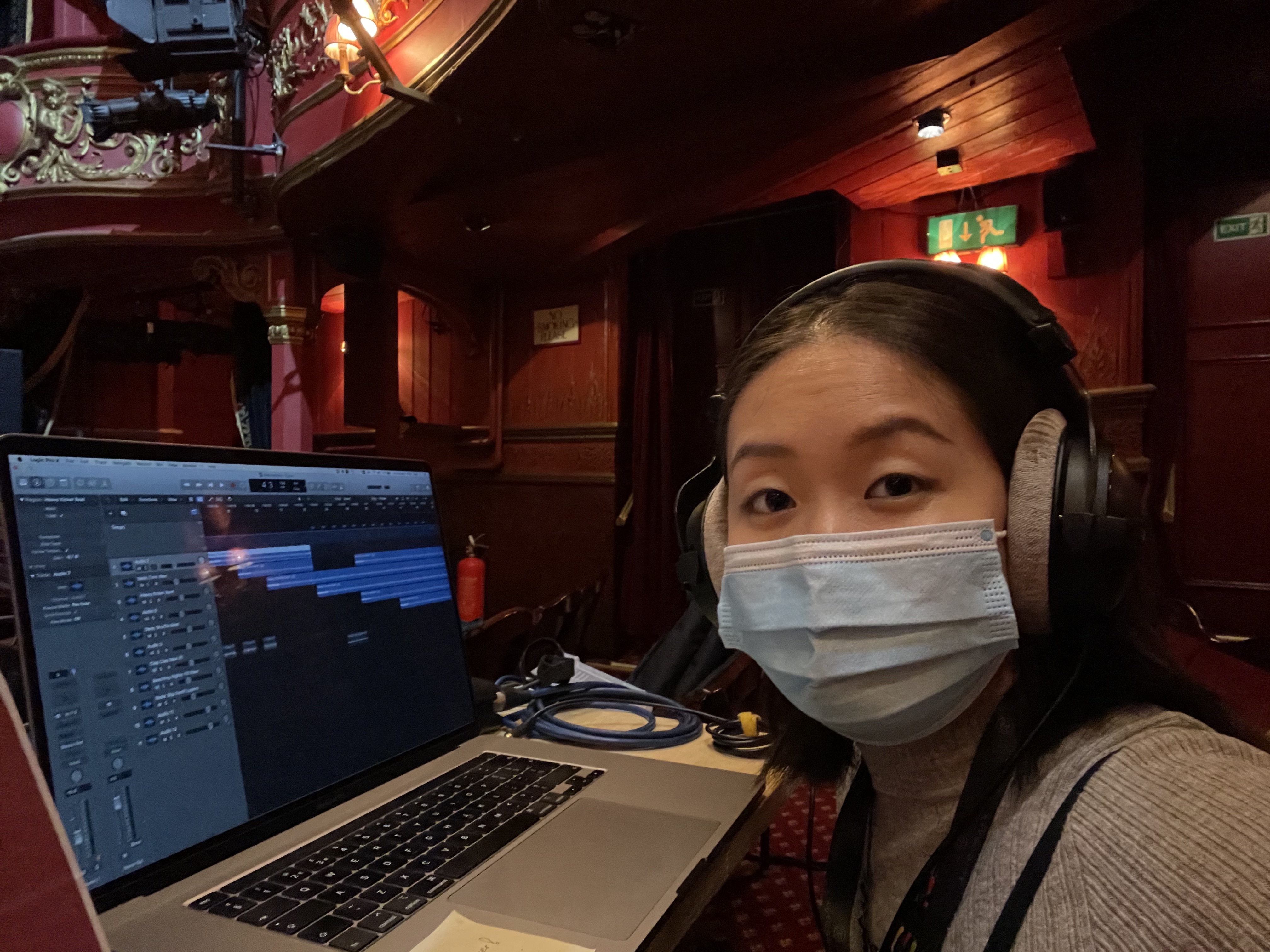 Photo of Tingying Dong in the Stratford East auditorium in front of her computer.