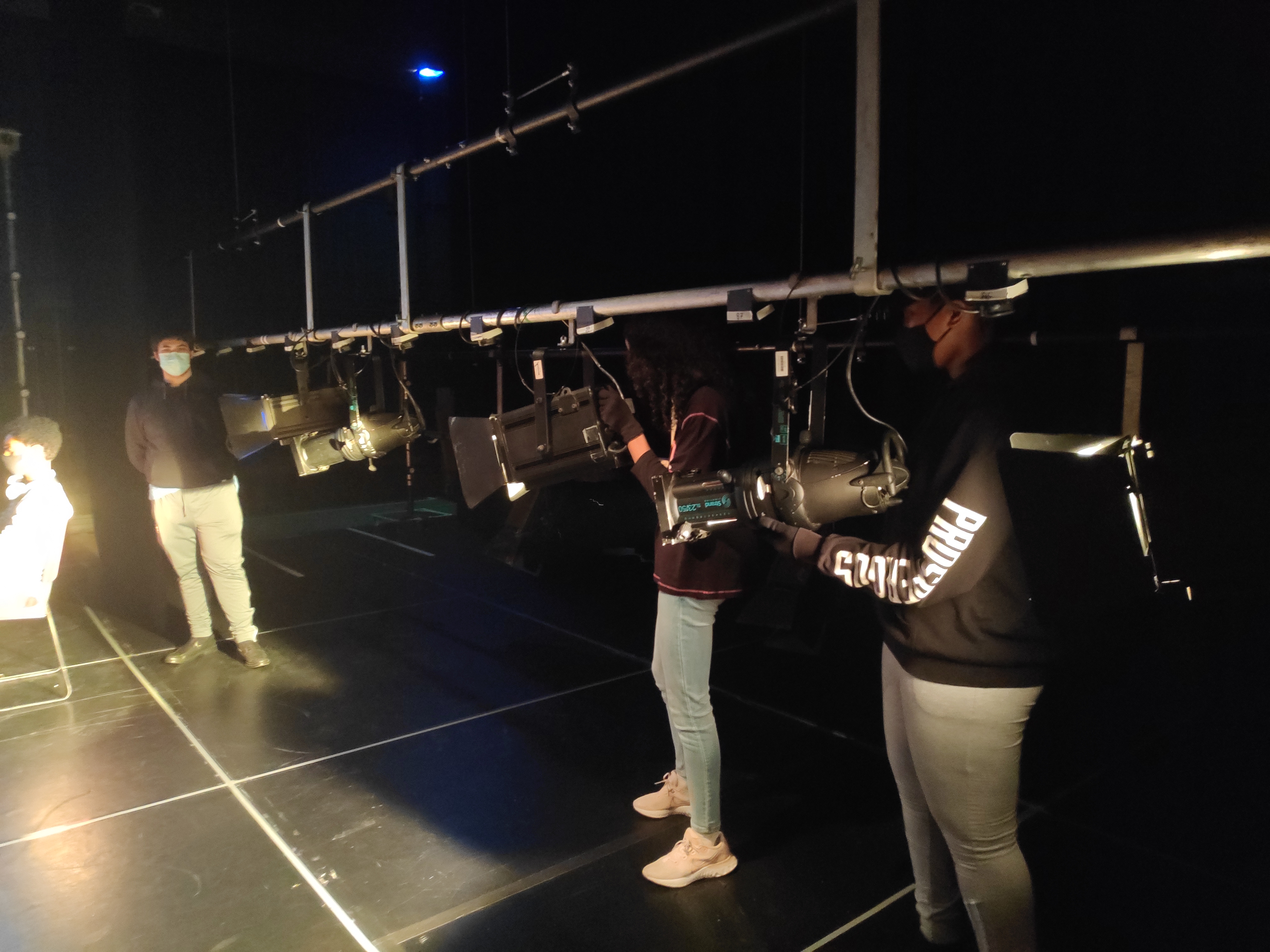 Photo of young technicians holding lights in the lighting rig